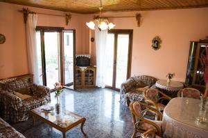 a living room with couches and a table and chairs at koula's apartments in Vasiliká
