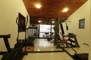 a gym with several tread machines in a room at Nooit Gedacht Heritage Hotel (Original Dutch Governors House) in Unawatuna