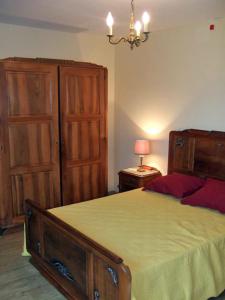 a bedroom with a bed and wooden cabinets and a lamp at La Ferme du Pech in Saint-Geniès