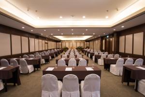 un salón de banquetes con mesas y sillas blancas en Imperial Phukaew Hill Resort, en Khao Kho
