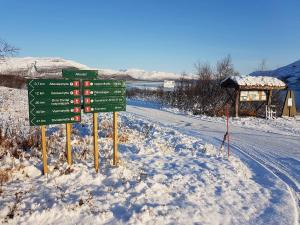 a street sign in the snow next to a road at Bardu Hotell in Sætermoen