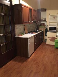 uma cozinha com armários castanhos e um balcão branco em Montemerano-Saturnia House Apartment em Montemerano