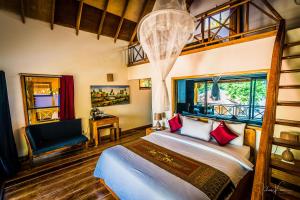 1 dormitorio con 1 cama, 1 silla y ventanas en Sol Beach Resort en Koh Rong Sanloem