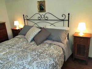 um quarto com uma cama com almofadas e 2 candeeiros em Montemerano-Saturnia House Apartment em Montemerano