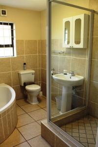 a bathroom with a toilet and a sink and a shower at Kian's Place Holiday Home in Langebaan