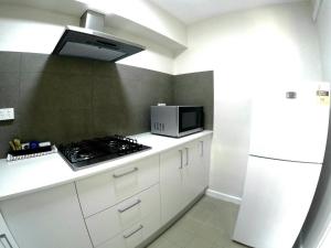 a kitchen with a stove and a microwave at City Waters in Perth
