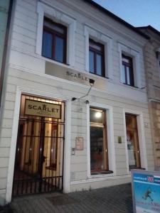 a white building with a sale sign in front of it at Penzion Scarlet in Trenčín