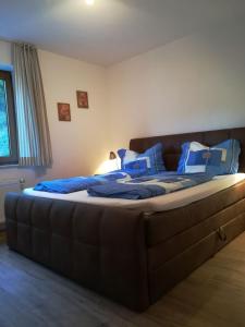 uma cama grande com almofadas azuis num quarto em Haus Schnurbus em Olsberg