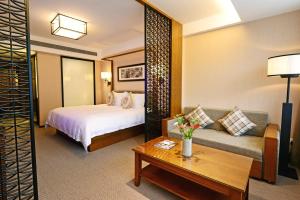 a hotel room with a bed and a couch at SSAW Boutique Hotel Hangzhou Qiandao Lake in Chun'an
