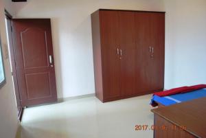 a bedroom with two wooden cabinets and a bed at Henry Corner in Chikmagalūr