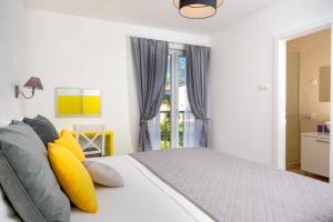 a bedroom with a bed with yellow and gray pillows at Villa Kala Komiža in Komiža