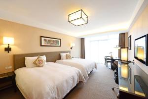 a hotel room with two beds and a flat screen tv at SSAW Boutique Hotel Hangzhou Qiandao Lake in Chun'an
