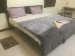 a large bed with purple pillows in a bedroom at ComfortWings in Coimbatore