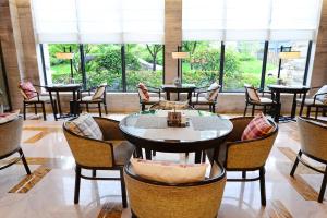 a restaurant with tables and chairs and large windows at SSAW Boutique Hotel Hangzhou Qiandao Lake in Chun'an