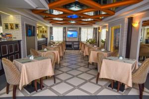 ein Restaurant mit Tischen und Stühlen in einem Zimmer in der Unterkunft Hotel SKY CENTR Krasnoyarsk in Krasnojarsk