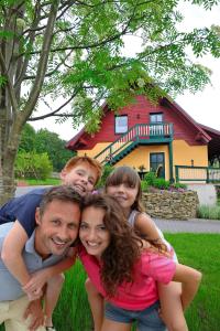 Eine Familie, die sich für ein Bild vor einem Haus ausgibt. in der Unterkunft Ferienwohnungen Weißflog in Schwarzenberg