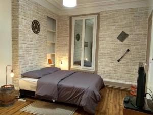 1 dormitorio con cama y pared de ladrillo en Chic apart in Paris en Saint-Denis