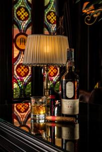 - une bouteille de vin et un verre sur une table avec une lampe dans l'établissement Hotel Moresco, à Venise