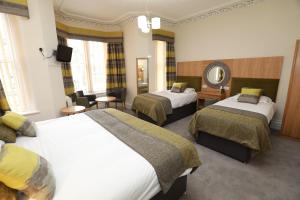 a hotel room with two beds and a mirror at The Famous Star Hotel Moffat in Moffat
