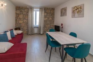 a living room with a red couch and a table and chairs at Oliva in Vrbnik