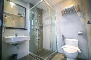 a bathroom with a shower and a toilet and a sink at INDRA HOTEL - BOUTIQUE SUITES in Ipoh