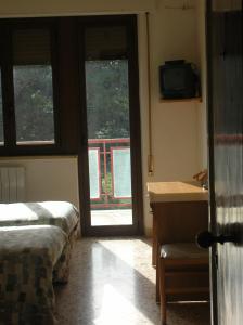 a bedroom with a bed and a desk and a window at MillePini in Calatafimi
