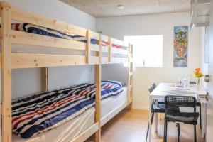 a bedroom with bunk beds and a table and a desk at Idestrup Bed and Breakfast in Idestrup +43 photos