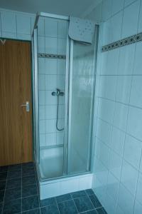 La salle de bains est pourvue d'une douche avec une porte en verre. dans l'établissement ferienwohnung Gabriele, à Schönau am Königssee