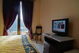 a bedroom with a bed and a television on a dresser at Hotel Varonos in Delphi