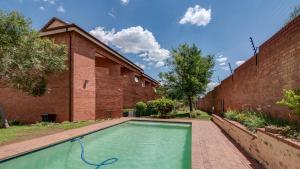 a swimming pool in front of a brick building at JoziStay @ Savannah Apartments in Little Falls