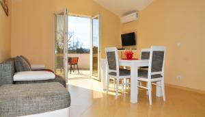 a living room with a table and chairs and a couch at Apartmani Bulajic in Tivat