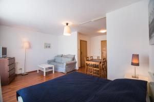 ein Schlafzimmer mit einem blauen Bett und ein Wohnzimmer in der Unterkunft Apartamenty Świnoujście - Róża Wiatrów in Świnoujście