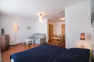 sypialnia z niebieskim łóżkiem i salon w obiekcie Apartamenty Świnoujście - Róża Wiatrów w Świnoujściu