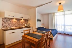 kuchnia i sypialnia z łóżkiem i stołem w obiekcie Apartamenty Świnoujście - Róża Wiatrów w Świnoujściu