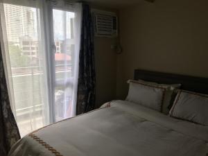 1 dormitorio con cama y ventana con vistas en Centrio Tower Beside Ayala Studio Unit 1 - 9 en Cagayán de Oro