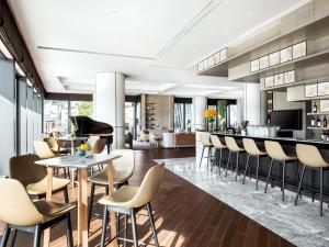a lobby with a bar and chairs and a piano at Cordis Shanghai Hongqiao (Langham Hospitality Group) in Shanghai