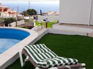 a lounge chair sitting next to a swimming pool at modern holiday apartment with private pool in Adeje