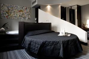 a bedroom with a black bed and a bath tub at Twentyone Hotel in Rome