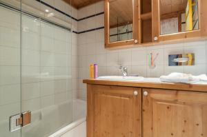 a bathroom with a sink and a shower at Résidence Pierre & Vacances Premium La Ginabelle in Chamonix +43 photos