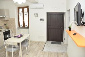 a kitchen with a wooden door and a table and chairs at Casa di Bacco in Vetralla