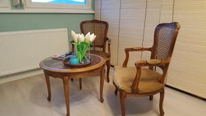 a table with a vase of flowers and two chairs at Widok na góry in Stronie Śląskie