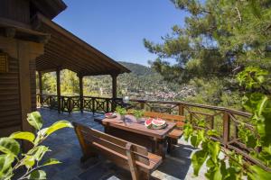 a patio with a table and benches on a deck at Ricky Chalet Near Troodos in Spilia