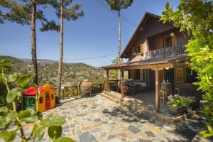 a house with a playground on a patio at Ricky Chalet Near Troodos in Spilia