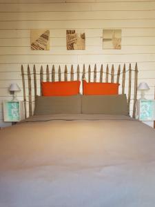 a bedroom with a large bed with orange pillows at Au Bois Flotté in Hourtin