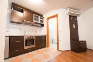 a kitchen with brown cabinets and an open door at Hotel Filipov in Kočani