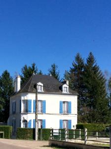 una casa blanca con persianas azules y una valla en Les rêves d'Angèle, en Crain