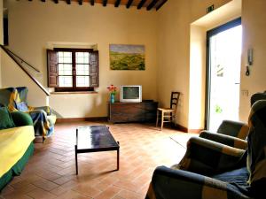 - un salon avec des canapés, une télévision et une table dans l'établissement Tenuta Monti, à Borgo San Lorenzo