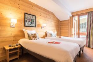 מיטה או מיטות בחדר ב-Résidence Pierre & Vacances Premium Les Chalets du Forum