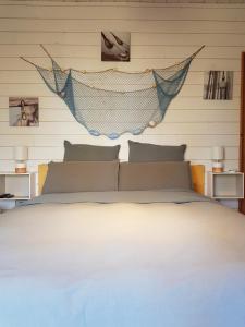 a bedroom with a bed with a hammock above it at Au Bois Flotté in Hourtin +34 photos