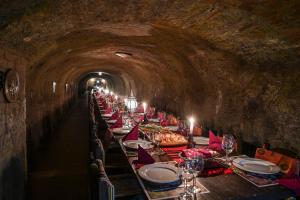 una larga línea de mesas en un túnel en Hotel Korona Wellness, Rendezvény és Borszálloda, en Eger